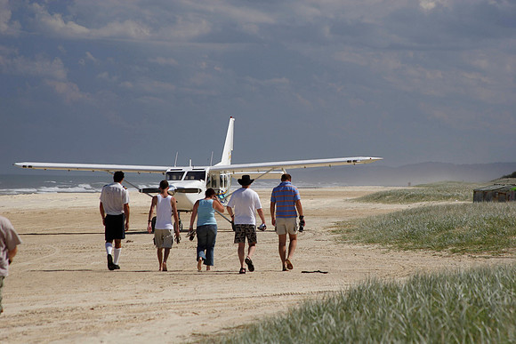 group heading out to the plane for a scenic aerial view of fraser island; the beach is also the runway